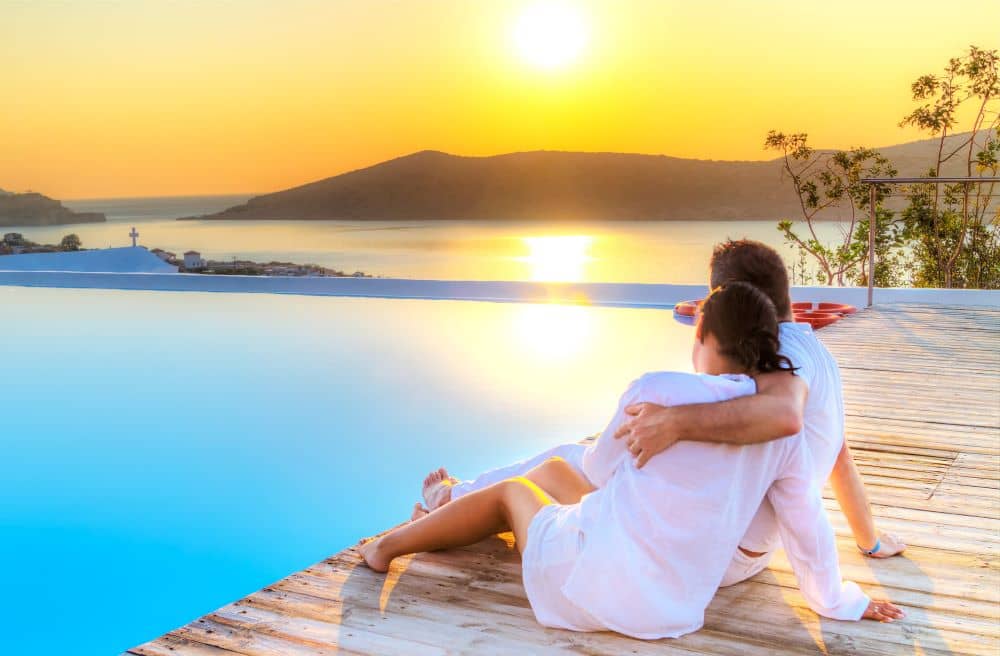 Couple watching the sunrise by the pool.