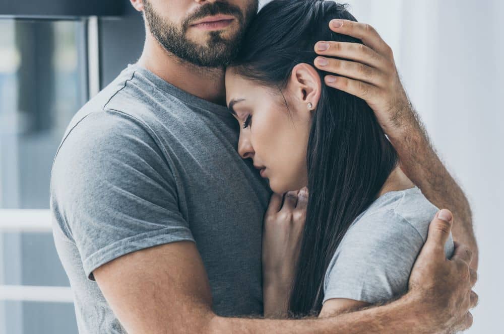 Man comforting a sad woman.