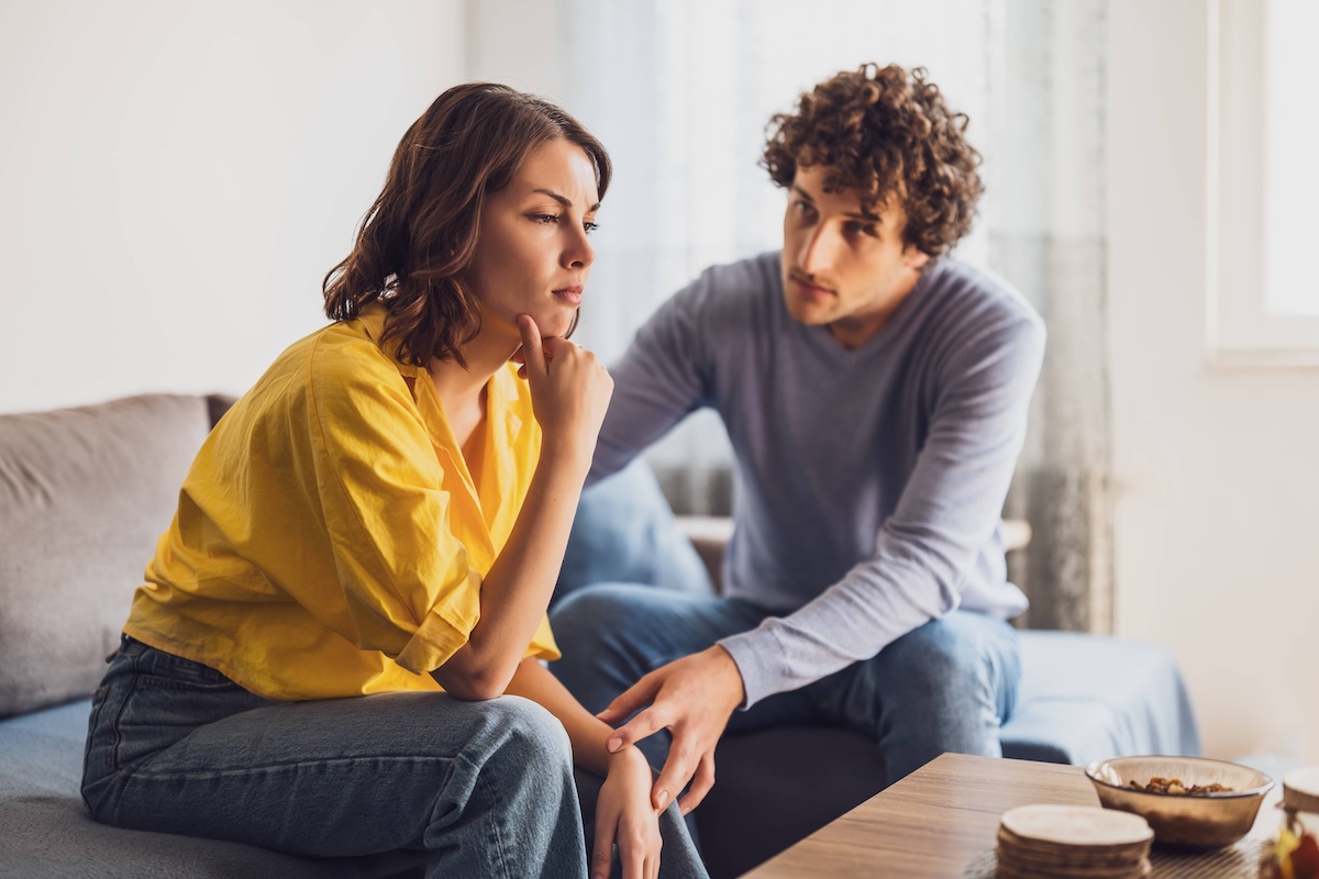 Man comforting lady on couch