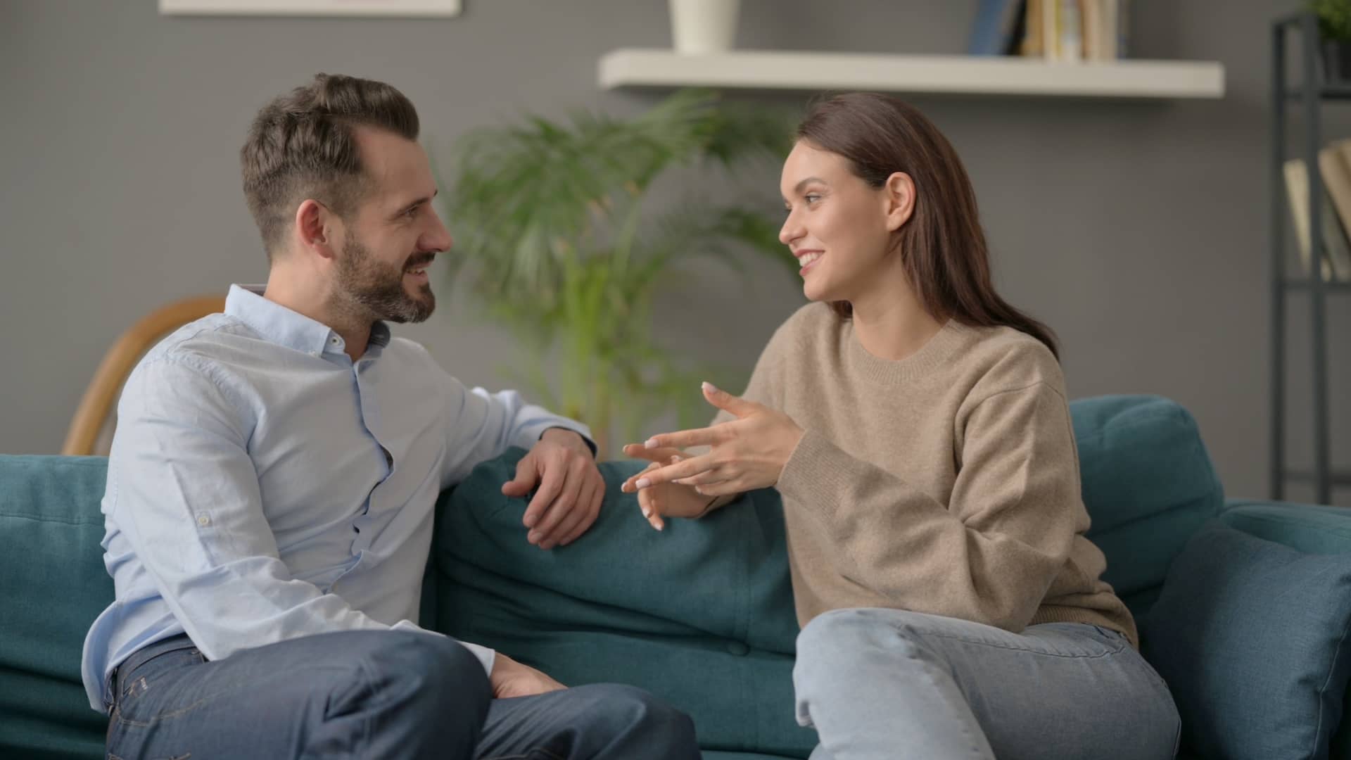 man and woman talking on couch