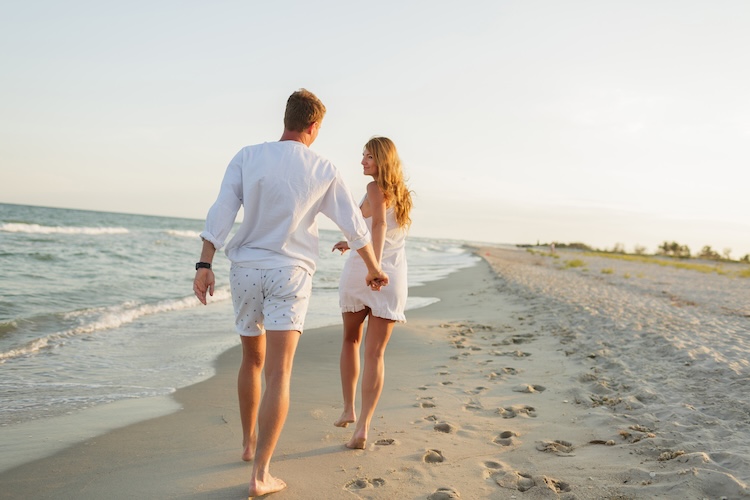 young couple on a sunset beach walk