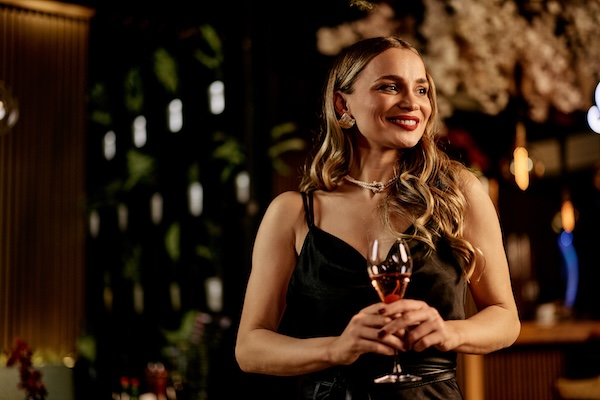 australian woman enjoying a glass of wine in a beautifully lit venue
