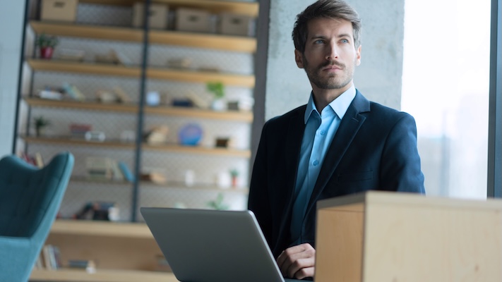 Businessman using laptop computer in office. Happy middle aged man, entrepreneur, small business owner working online