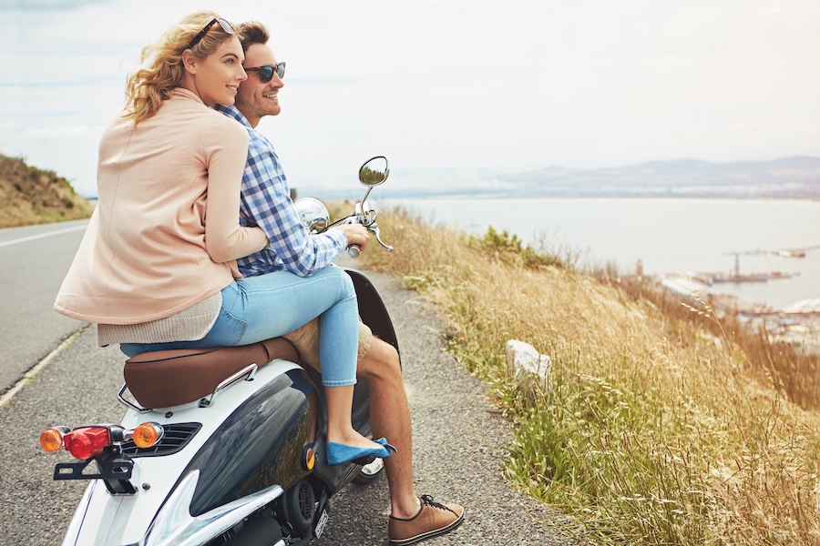 Hug, road trip and view with couple on scooter for adventure, love and bonding. Date, honeymoon and romantic vacation with man and woman travel outdoor for journey, transportation and bike space